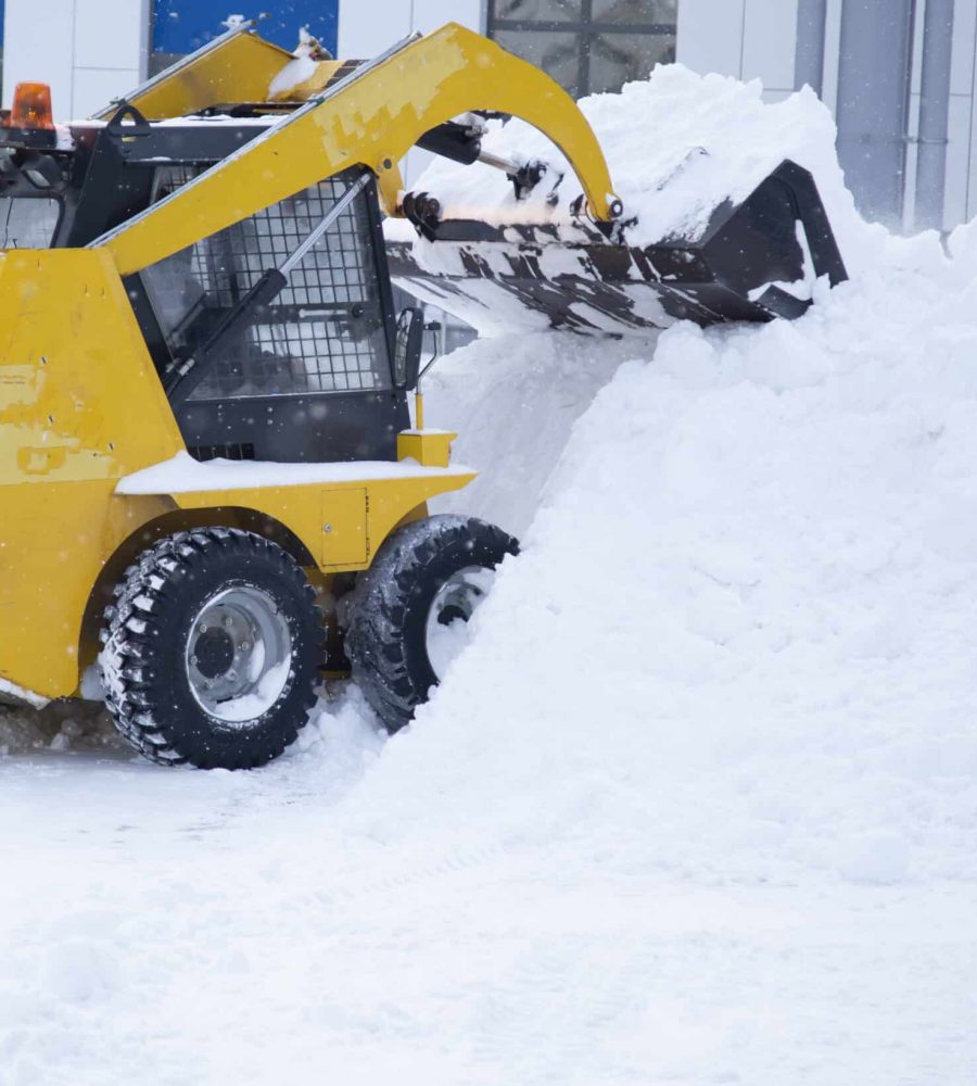 Snowfall.There is a lot of snow in the city.Snow removal by a special tractor.